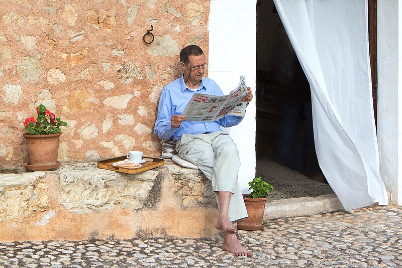 Mann liest vor einer Finca, Finca Mallorca